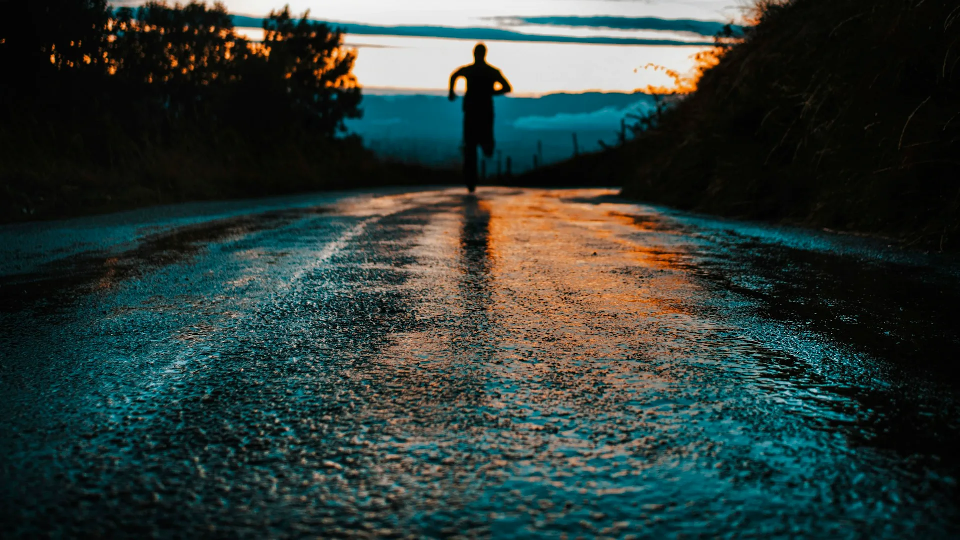 Silhouette of a runner on a road at sunset