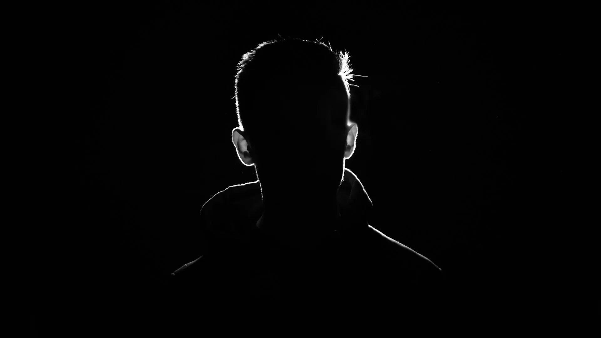 Silhouette of a lone figure in low, atmospheric light at night