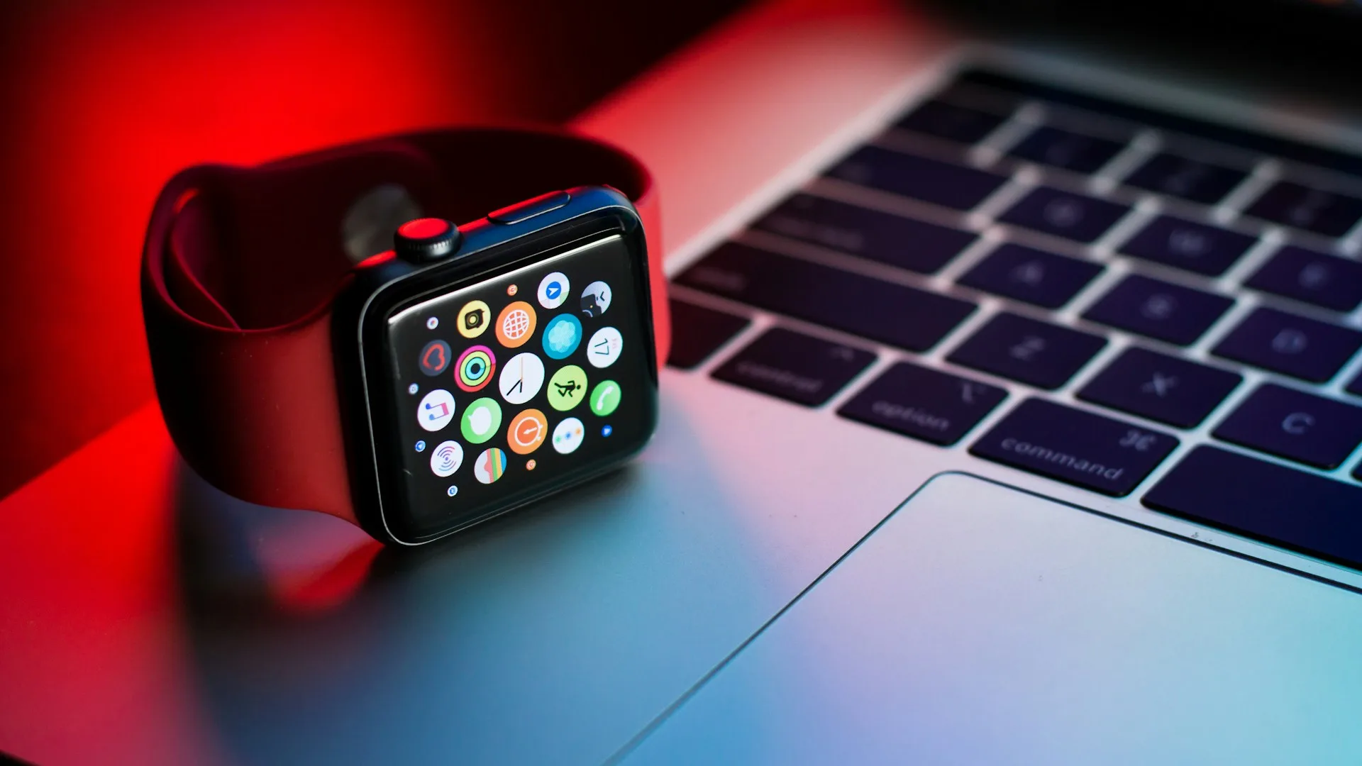 Close-up of a space-black Apple Watch resting on a dark surface in low light